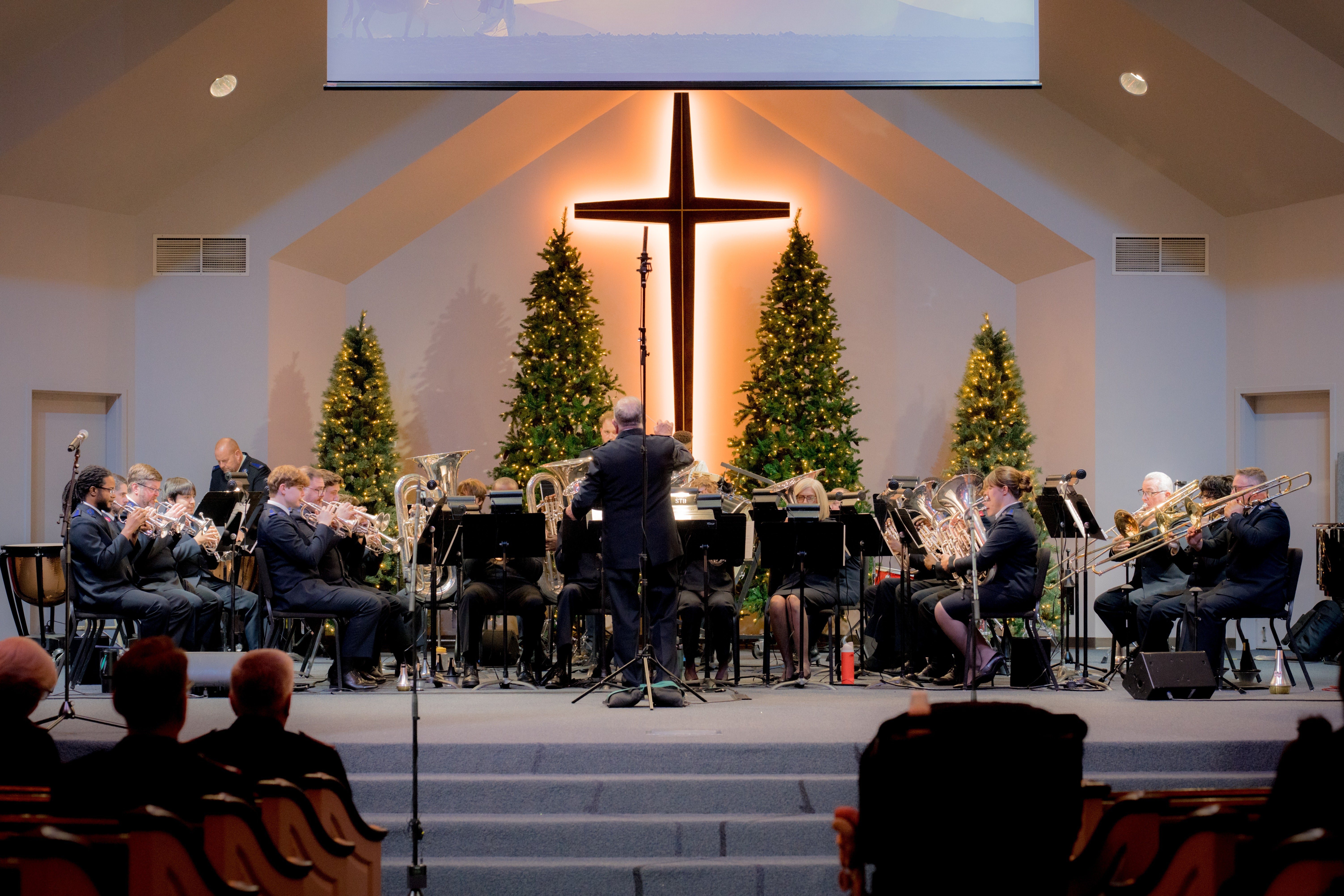 The Atlanta Area Christmas Concert, with musicians and singers gathered beneath a large Christmas tree