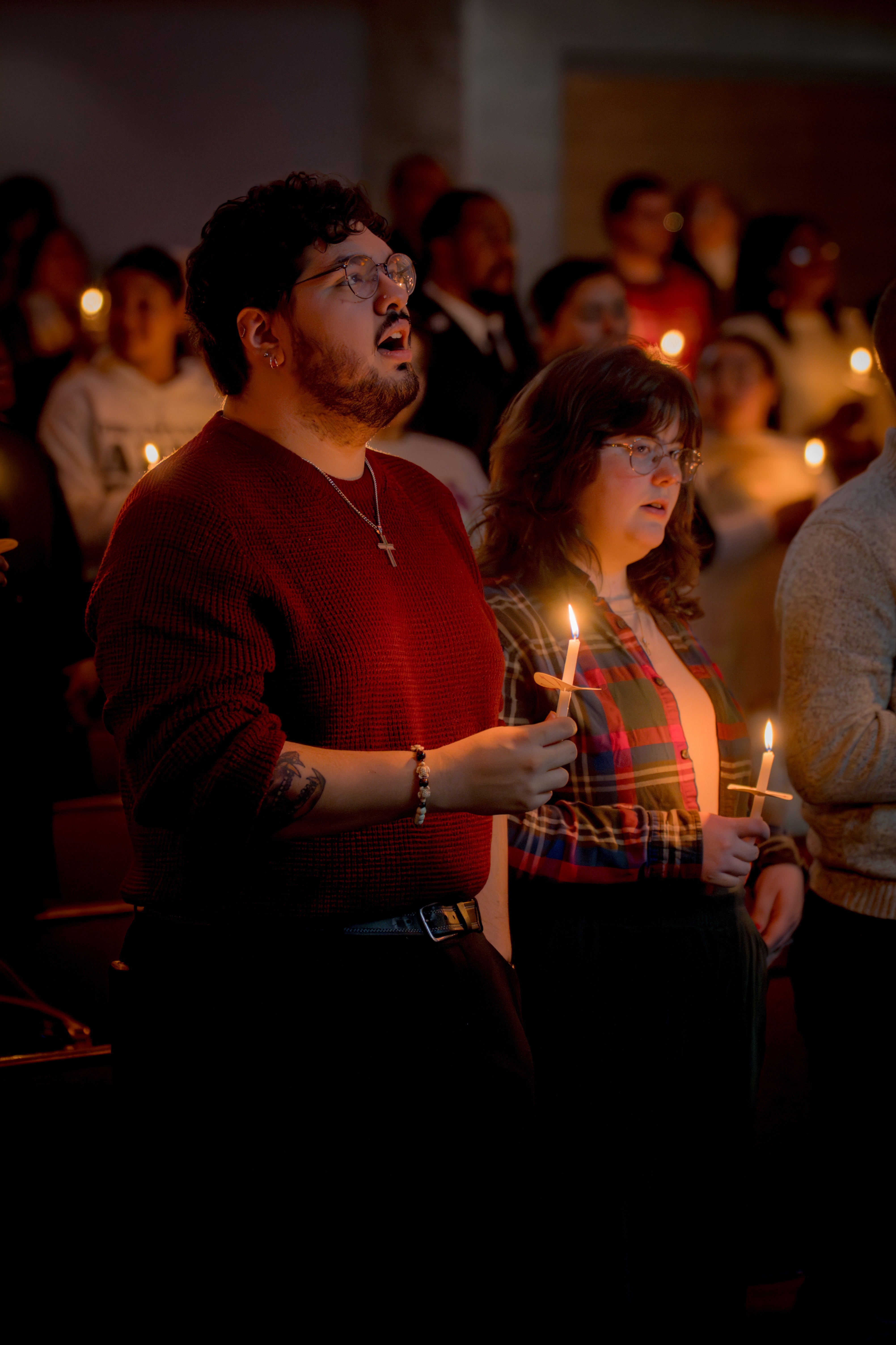 A congregation holds candles during a Christmas service