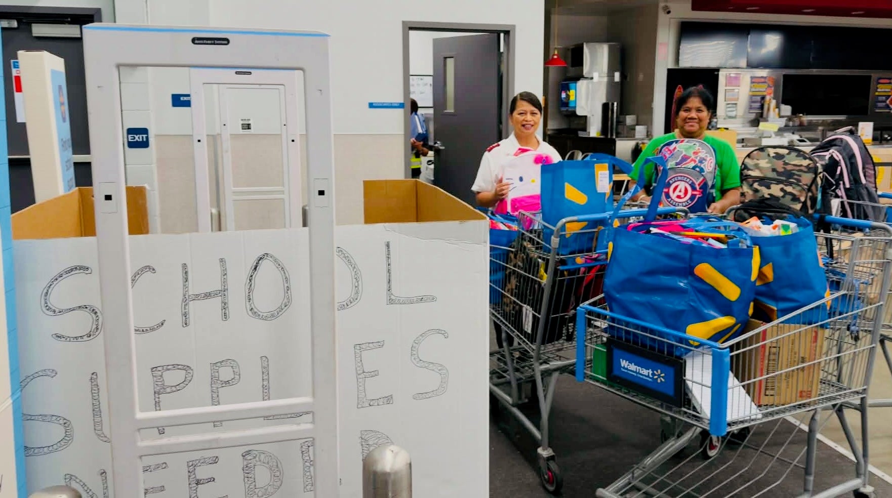 Volunteers and shoppers collect school supply donations at a Stuff the Bus event at a Honolulu Walmart