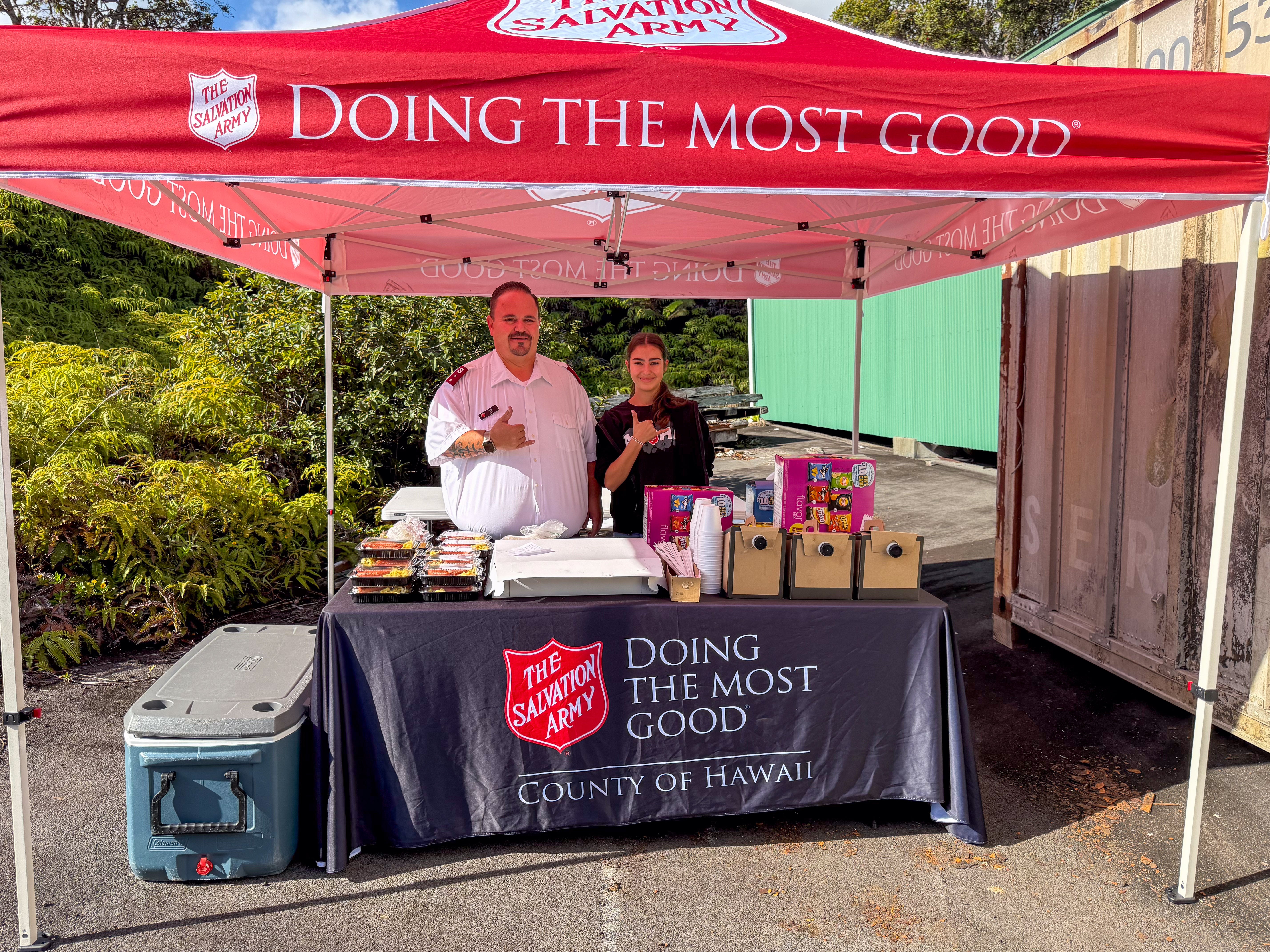 Captain Sam LeMar and daughter serving meals from The Salvation Army tent