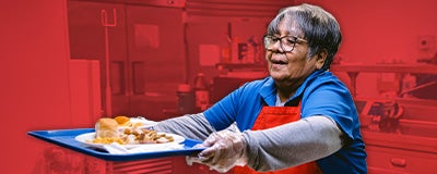 Salvation Army volunteer serving tray with food