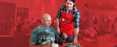 Salvation Army volunteer serving tray with food